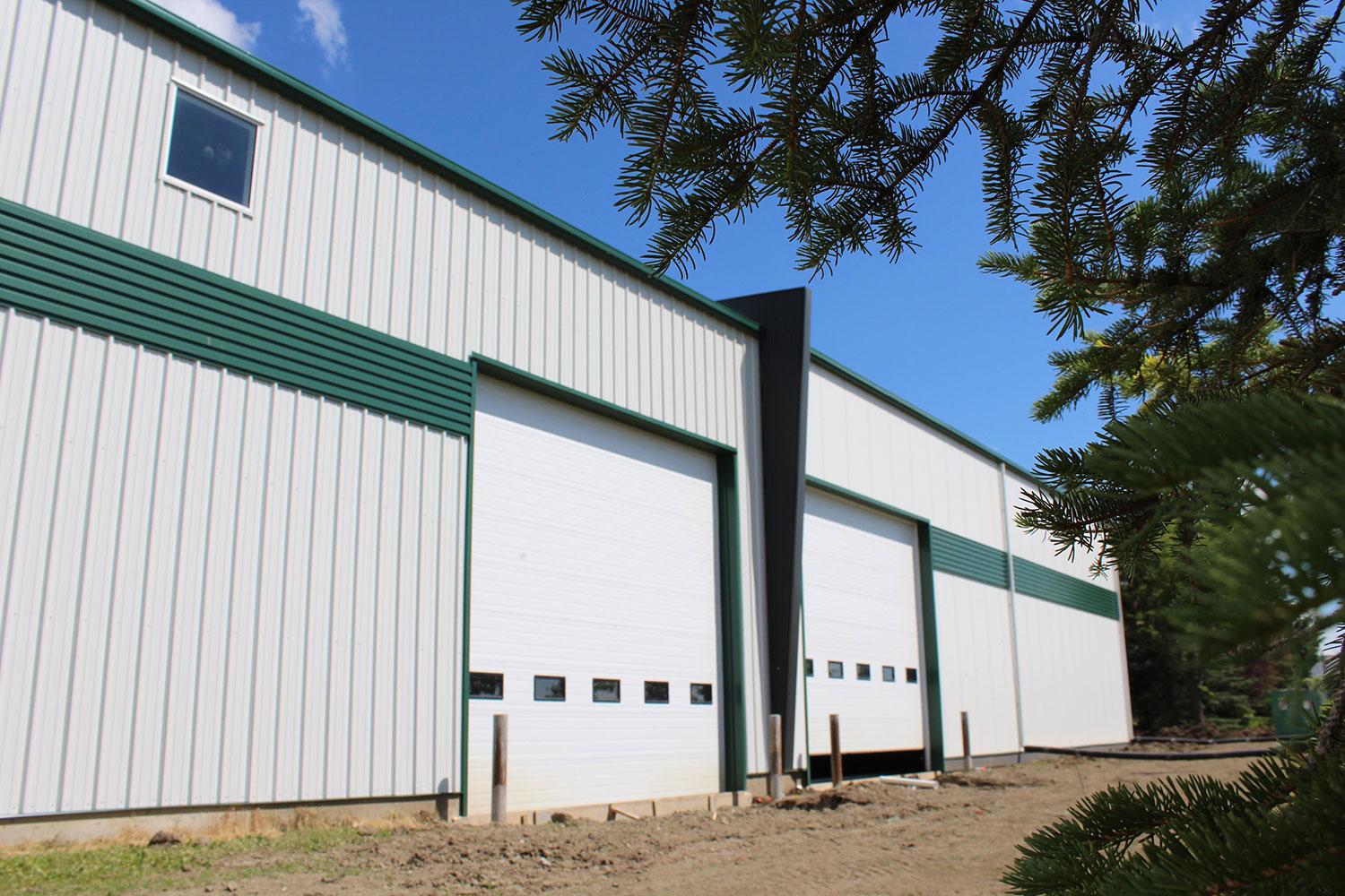 Commercial Building with 7/8 Corrugated in Carbon, Espresso Woodgrain Soffit, and custom panels in Melchers Green and Bright White