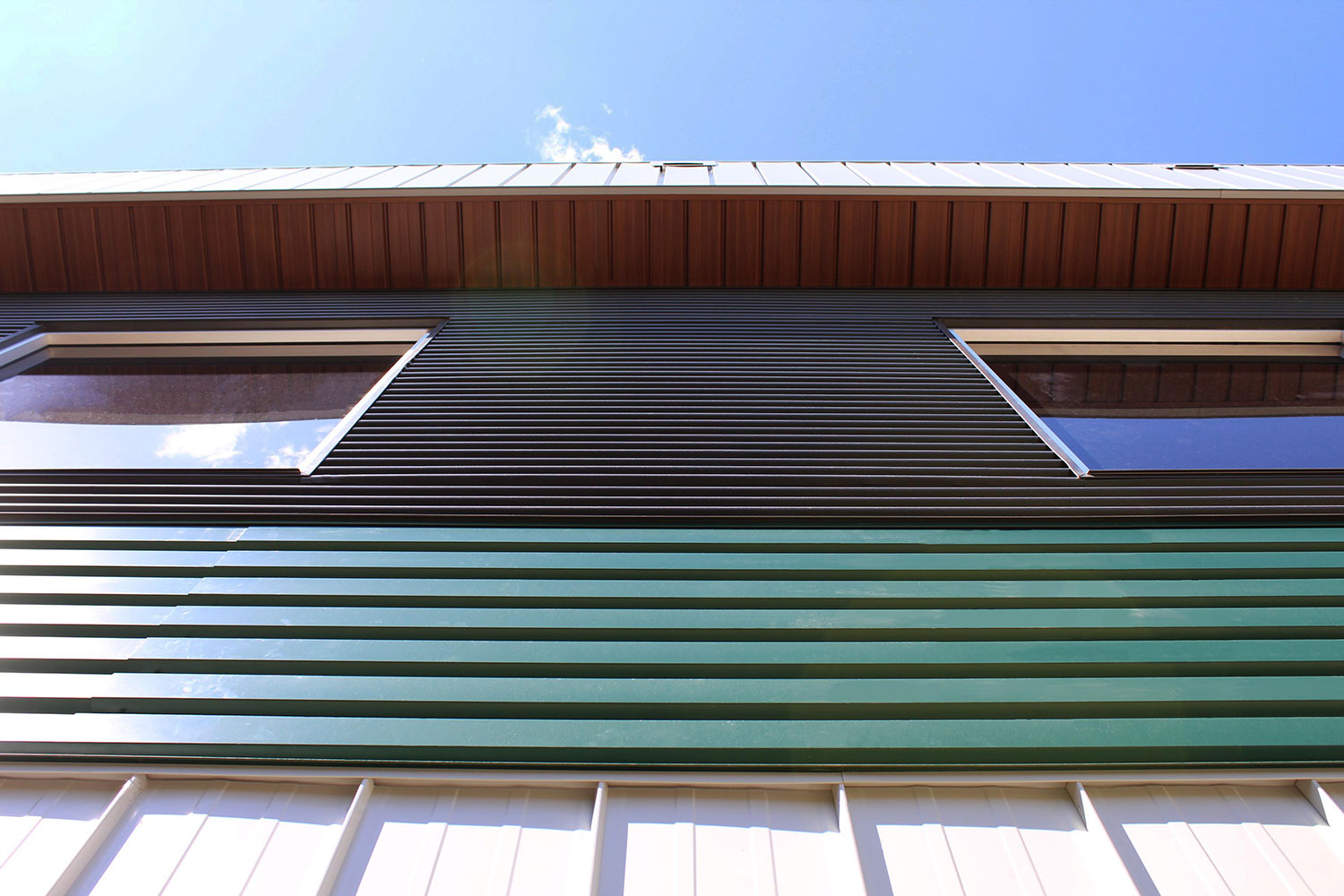 Commercial Building with 7/8 Corrugated in Carbon, Espresso Woodgrain Soffit, and custom panels in Melchers Green and Bright White