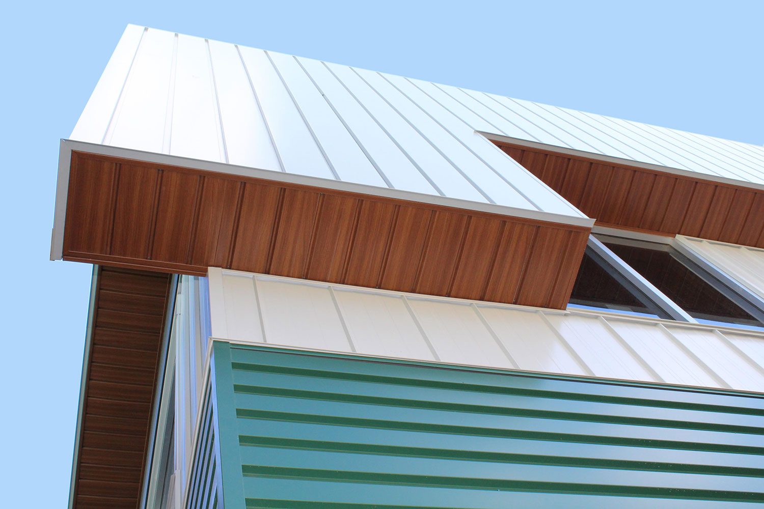 Commercial Building with 7/8 Corrugated in Carbon, Espresso Woodgrain Soffit, and custom panels in Melchers Green and Bright White