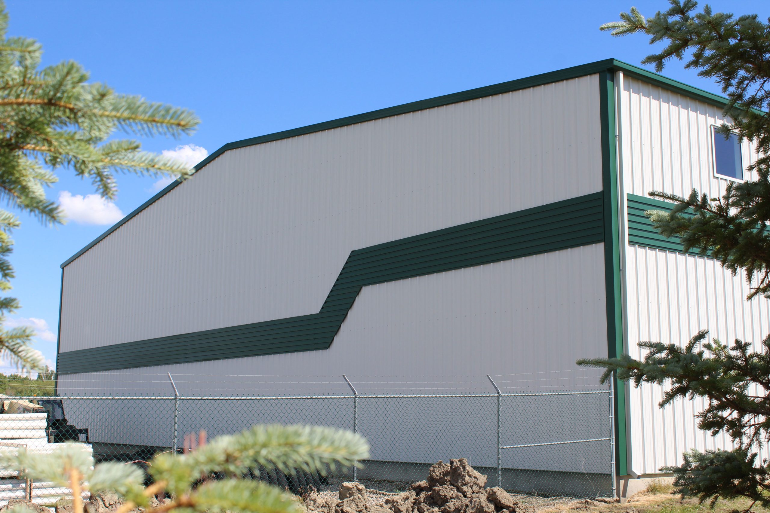 6" Box Rib in Melcher's Green for commercial building Bos Sod. Also includes our Board and Batten panels in Arctic White.